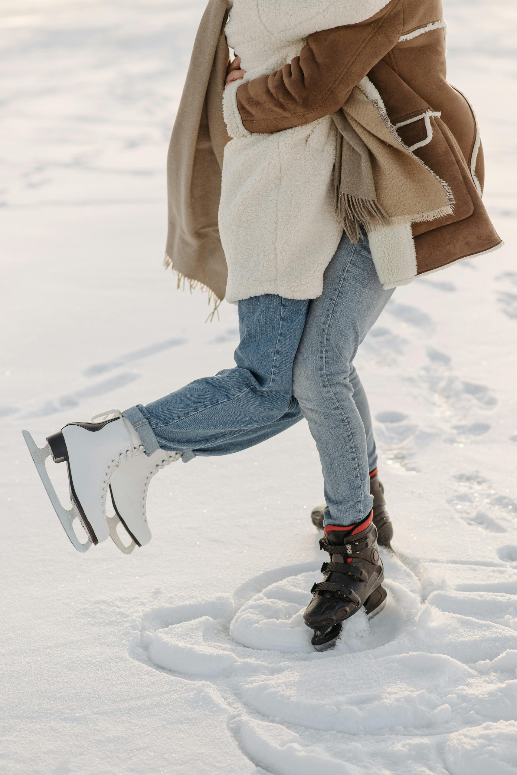 A couple skating on snow-covered ice, spinning in a circle.