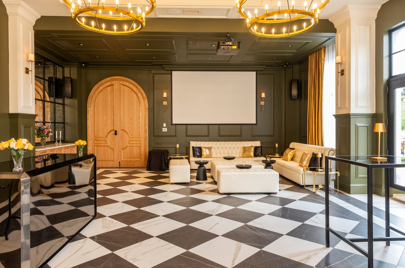 An events space at the Lord Elgin Hotel with black and white checkered marble floors, green and white walls, and large brown wooden doors.