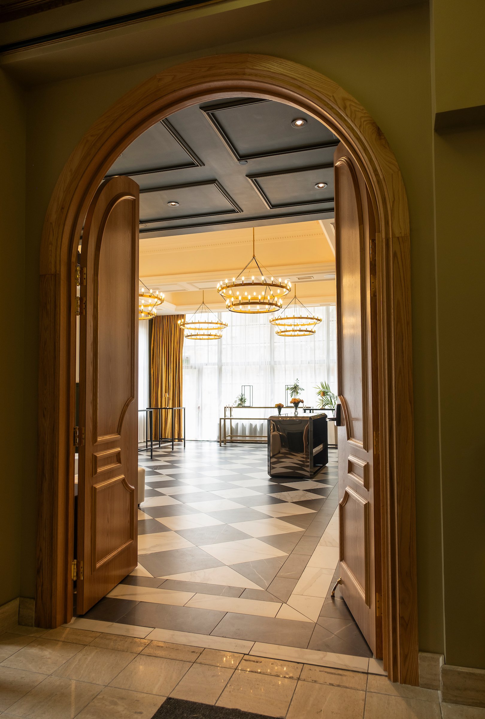 Entrance to the Trillium Room event venue, a stylish and welcoming gateway to a unique event experience. Luxurious chandeliers decorate the space.