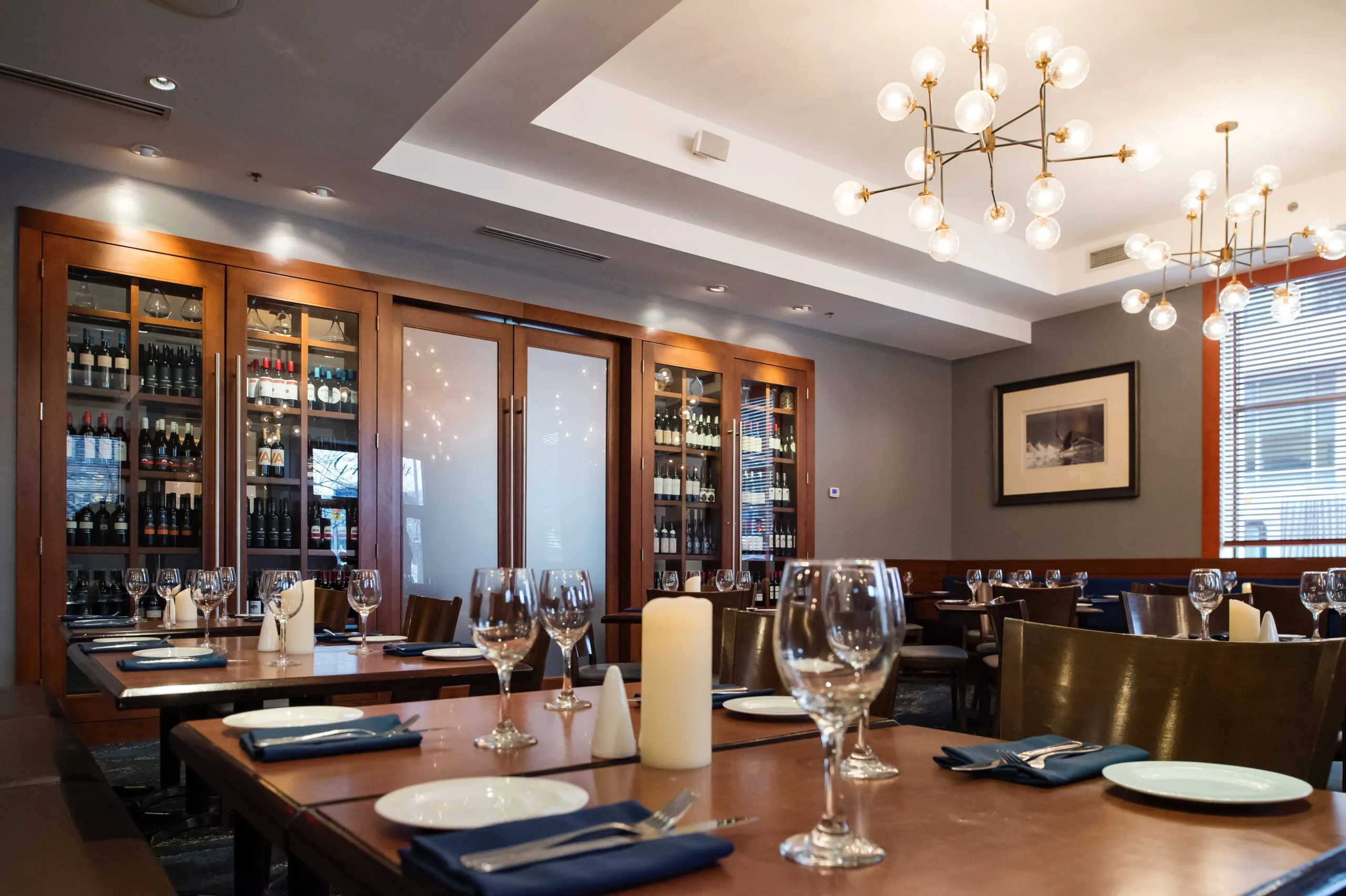 Dining room at Forty One, with brown wood tables, blue napkins and clear wine glasses.